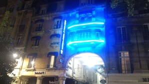 A building with a large archway entrance, a sign for 'Timberland', and another sign for 'MEPHISTO'. - Hotel des Arcades (Reims)