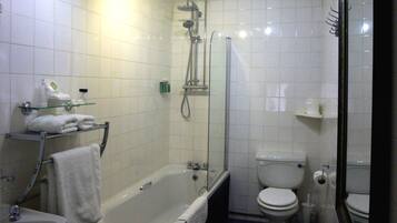 Un baño moderno con bañera, inodoro y ducha con mampara de vidrio.