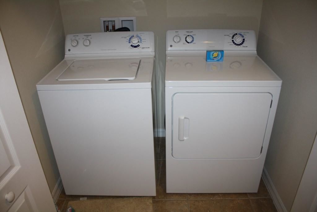 A laundry room with two stacked washers and dryers.
