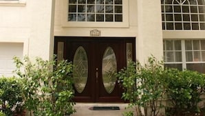 A building with a symmetrical facade, large arched windows, and a central entrance with a dark door. - Doral Woods (Kissimmee)