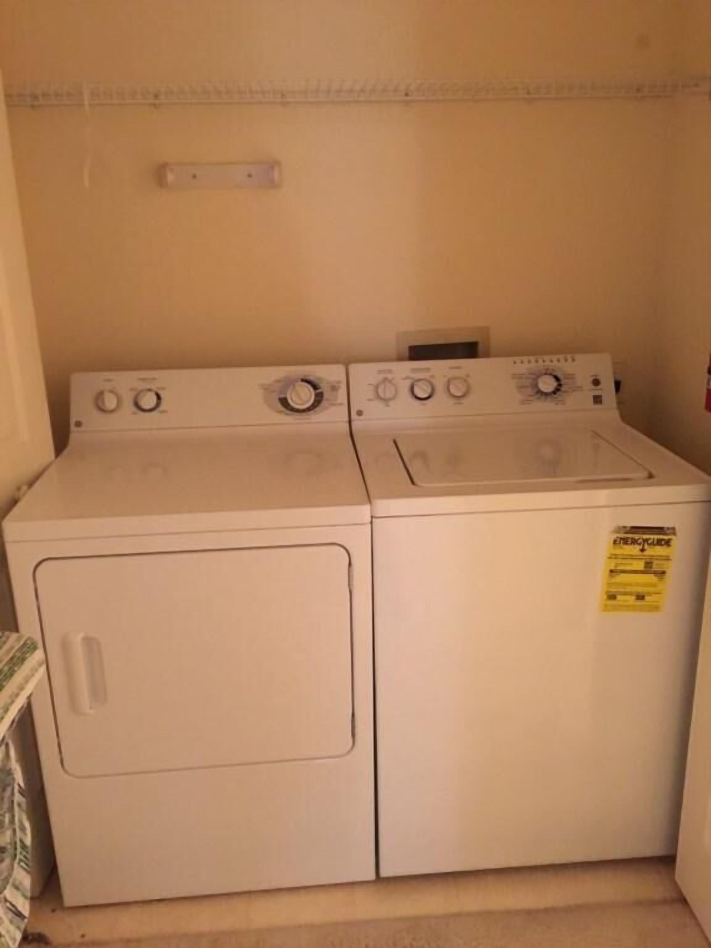Une buanderie équipée de deux machines à laver et deux sèche-linge superposés.