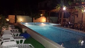 Una piscina al aire libre de temporada, sombrillas, tumbonas