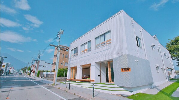 Un edificio moderno con techo plano, ventanas amplias y una placa con el año visible.