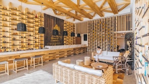 Ein modernes Interieur mit Holzbalken, einer zentralen Sitzecke und Regalen mit verschiedenen Gegenständen.