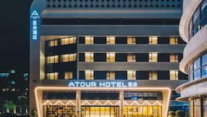 Ein mehrstöckiges Hotel mit modernem Design, das eine markante, beleuchtete Eingangszone besitzt.
