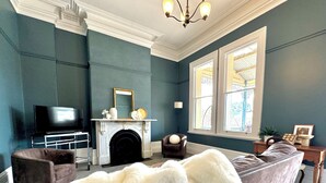 Una sala de estar con chimenea, televisor, sofá y un manto de piel grande.