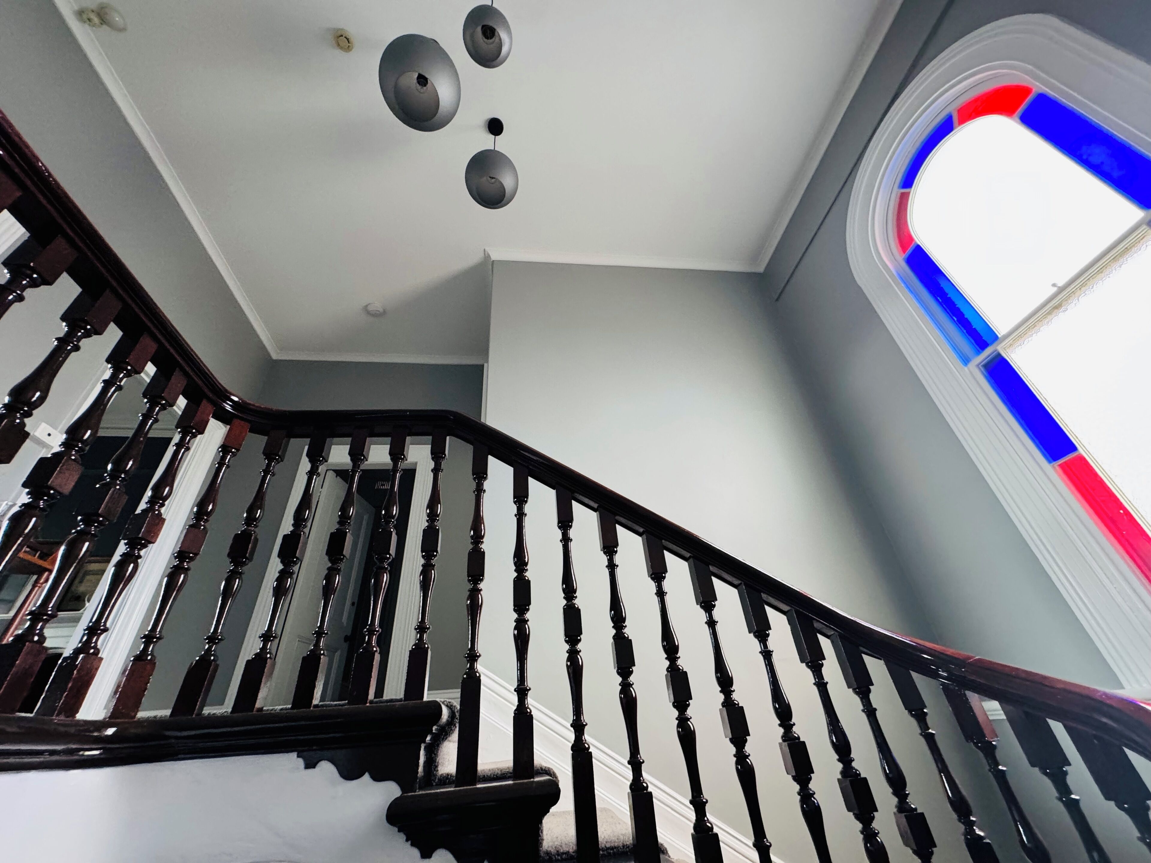 A staircase with dark wooden balusters and a white wall.