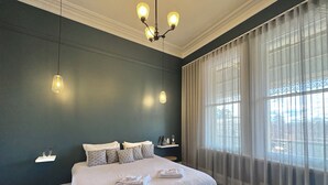 Un dormitorio con una cama grande, una araña y cortinas de gasa.