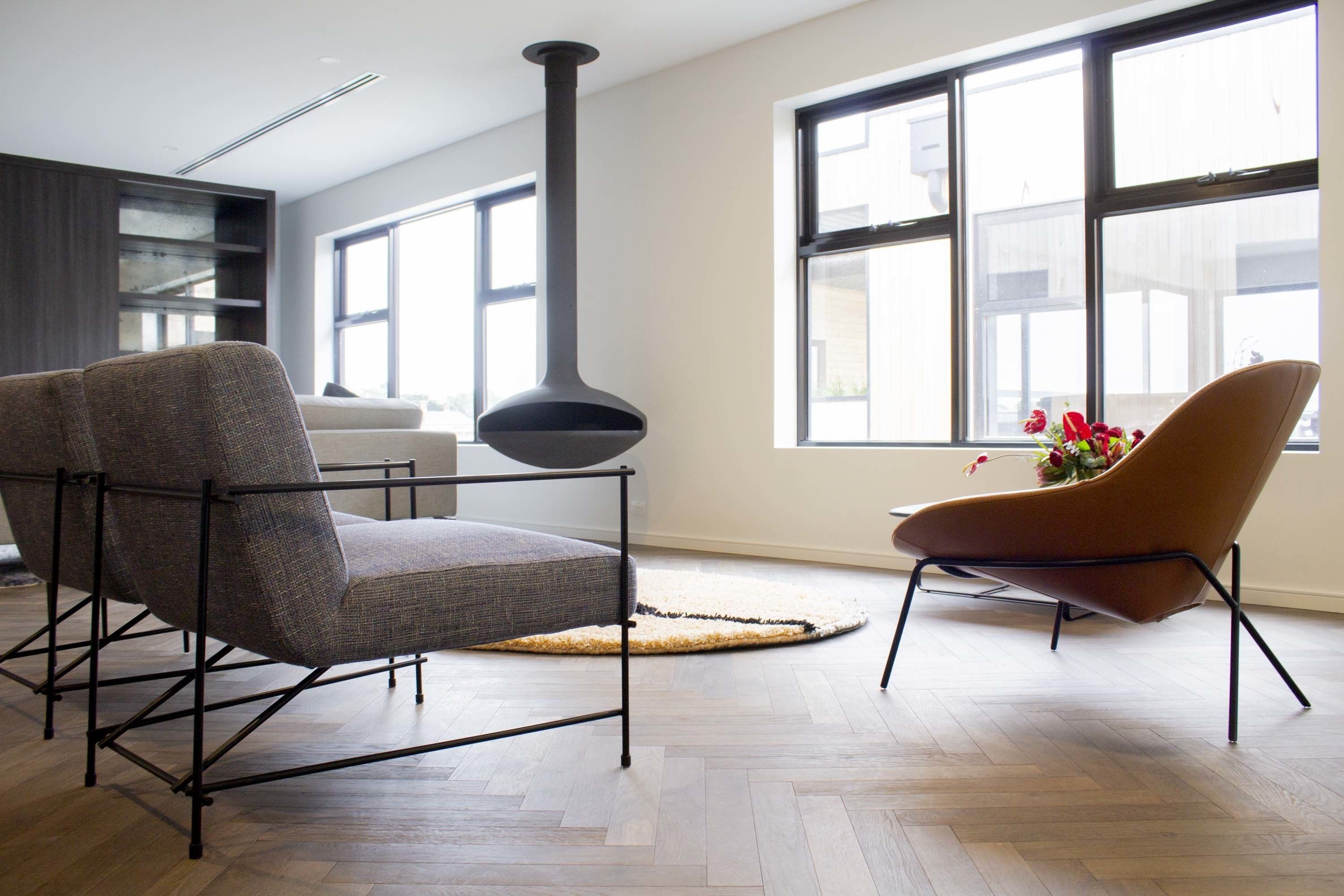 A modern living room with a fireplace, a sofa, and a chair.