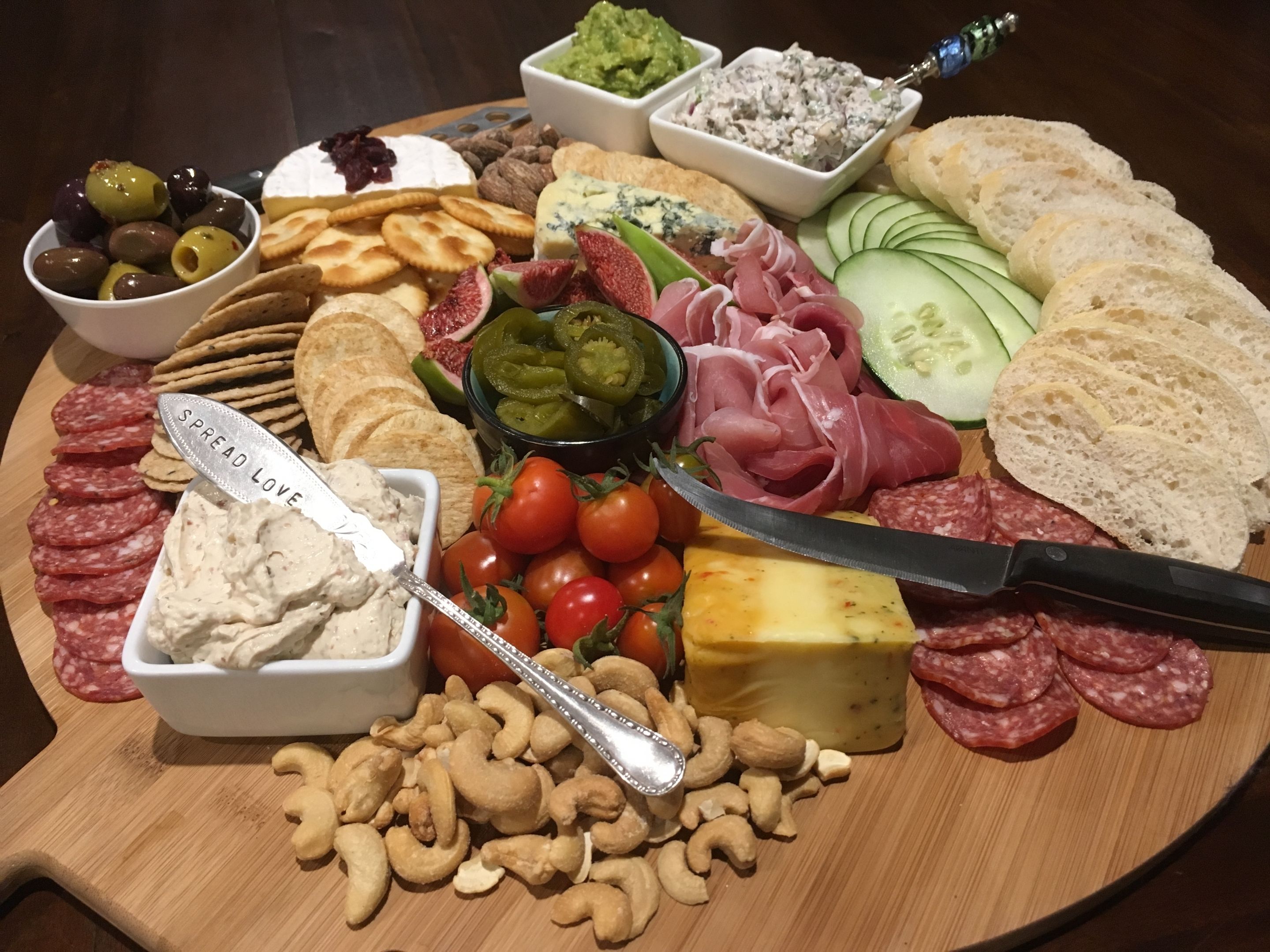 Une planche de charcuterie avec divers fromages, viandes et fruits secs.