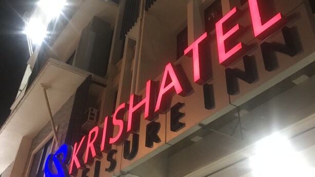 Ein Gebäude mit einem Schild, auf dem „KRISHATEL LEISURE INN“ steht.