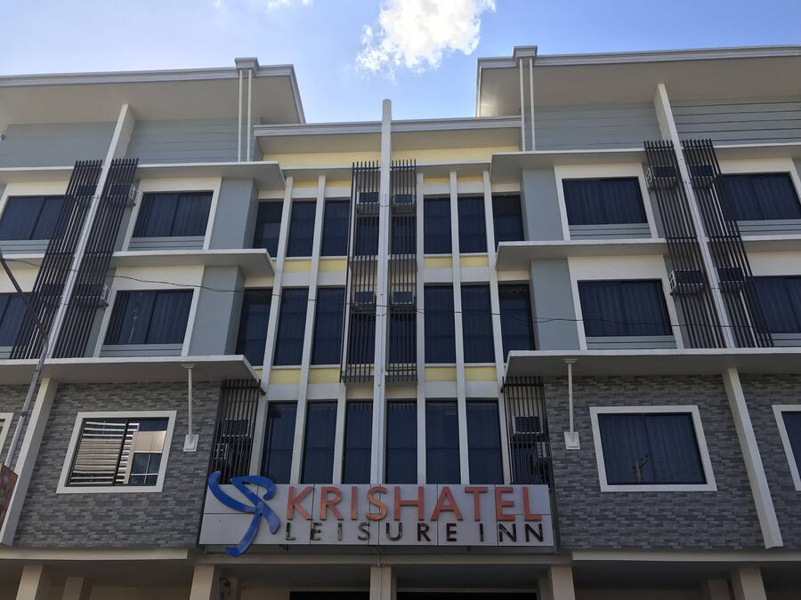 Un immeuble à plusieurs étages portant une enseigne indiquant « KRISHATEL LEISURE INN ».