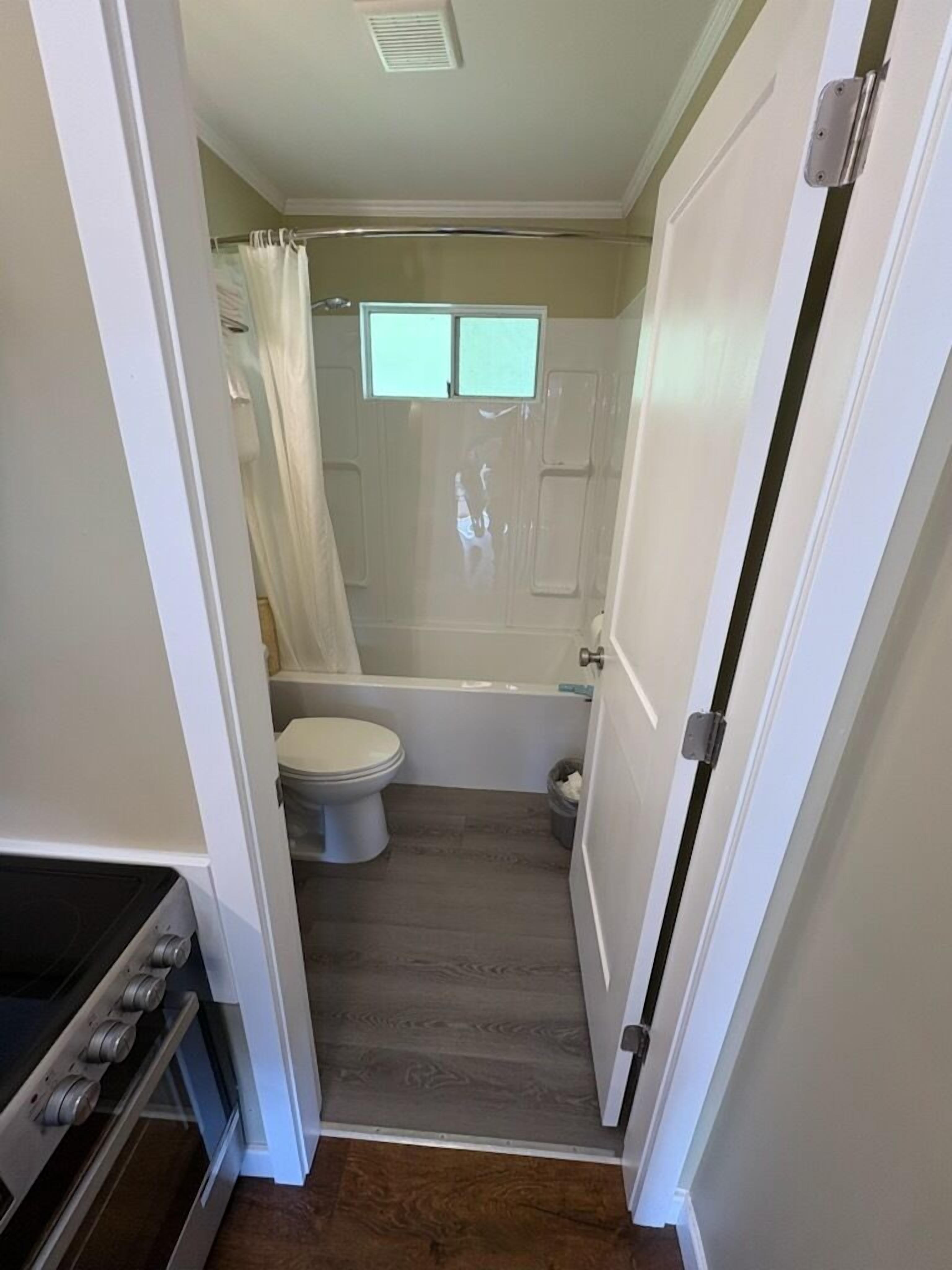 Ein kleines Badezimmer mit Toilette, Badewanne und Duschvorhang.