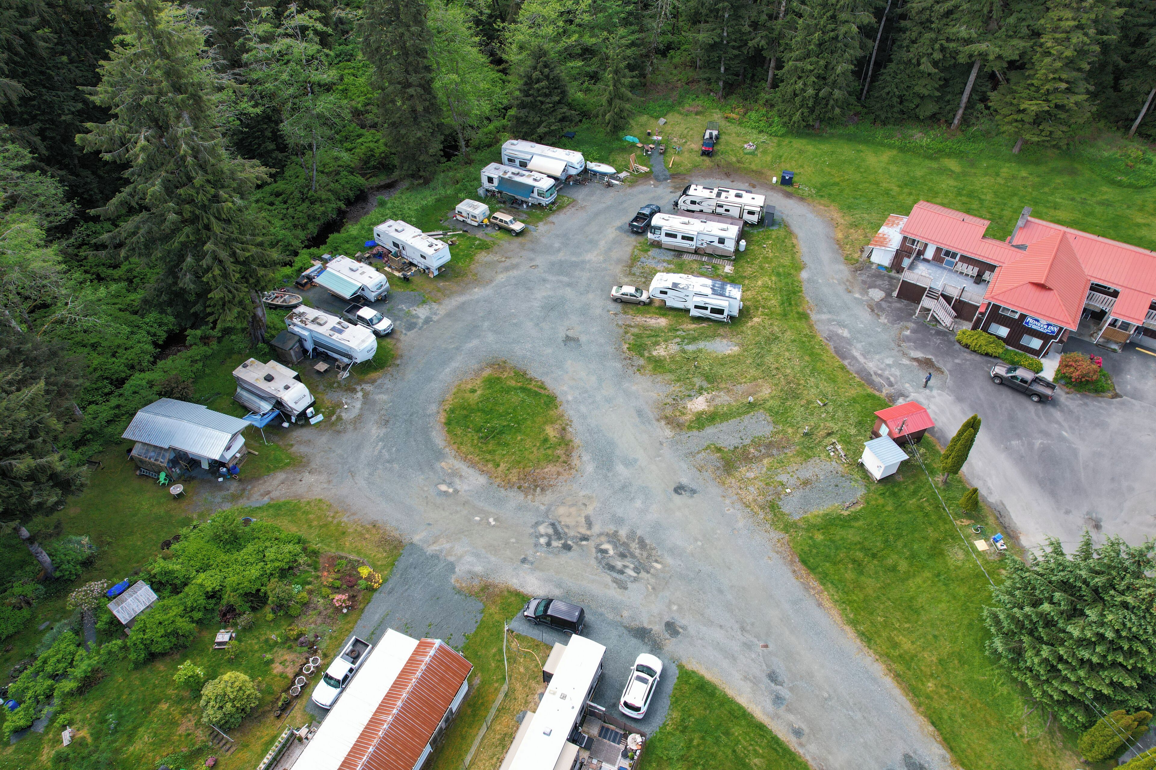 An aerial view of a campground with RVs, a building with a red roof, and a parking area.
