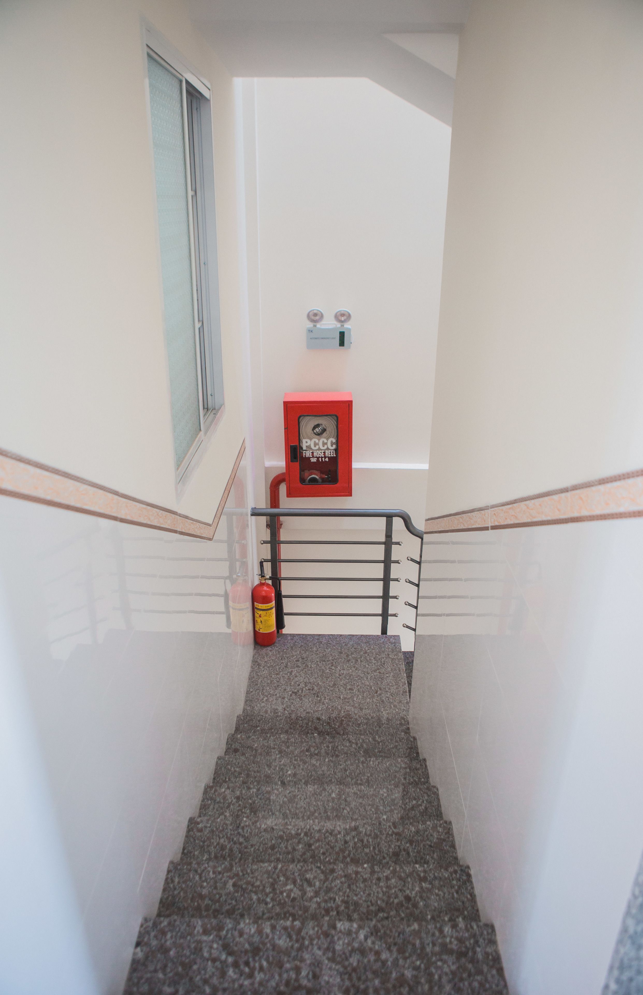 Eine Treppe mit einer Brandschläucherahne und einem Brandmelder.