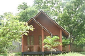 A single-story building with a sloped roof and a balcony. - The Bell Farm Eco Resort (Kandalama)