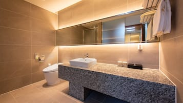 A modern bathroom with a white sink, a toilet, and a large mirror.