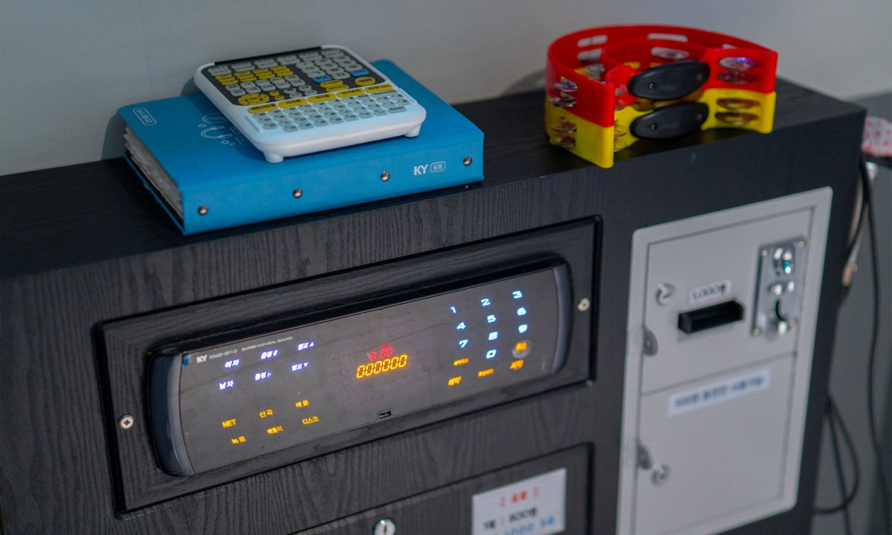 A control panel with a digital display, a keypad, and a small blue device on top.
