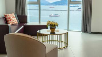A modern living room with a view of a body of water and boats.