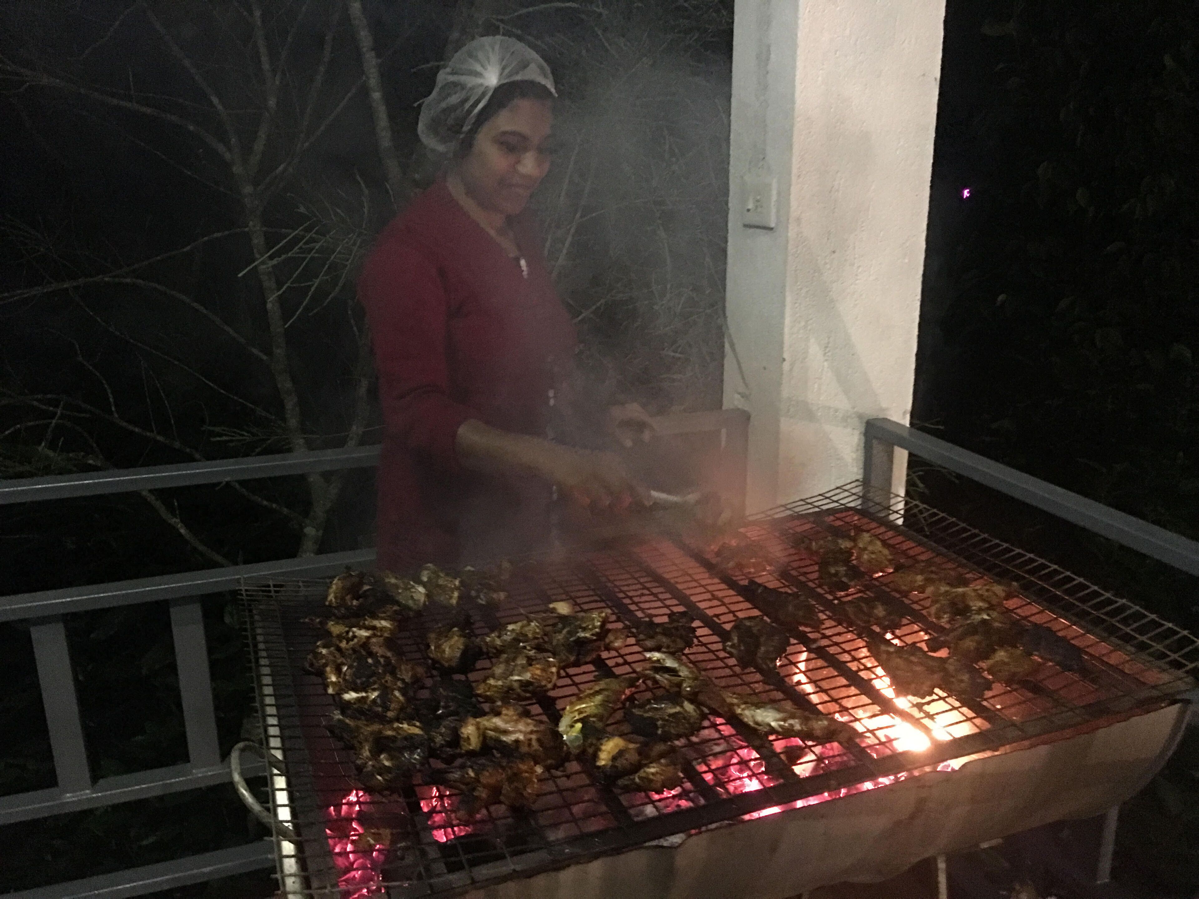 A person grilling food outdoors at night.