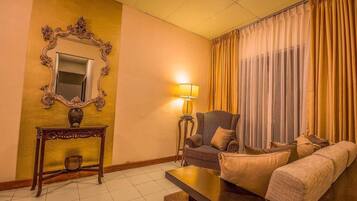 Relax in style with a comfortable armchair, plush sofa, and ornate mirror.