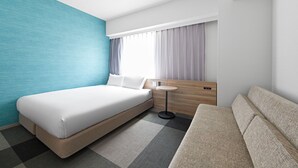 Una habitación de hotel moderna con una cama grande, un sofá, una pequeña mesa redonda y una ventana con cortinas.