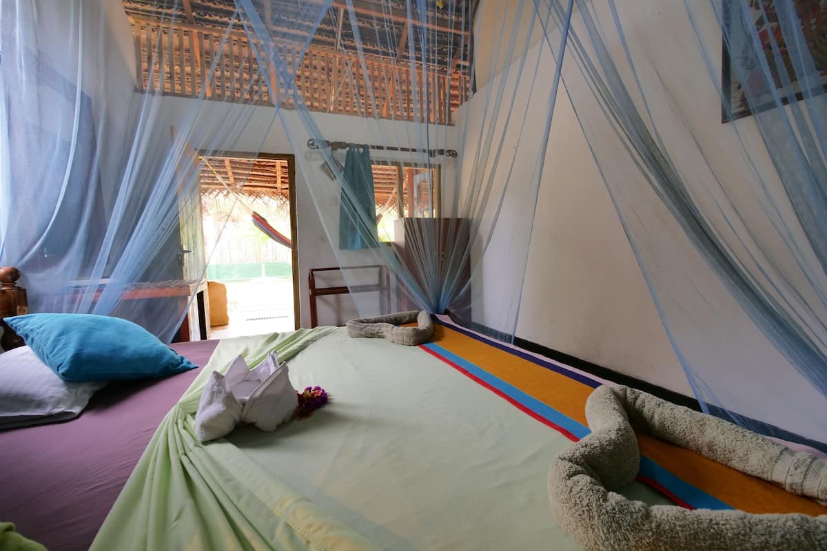 A room with a bed, a chair, and a window.