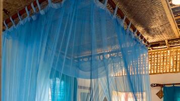 A room with a canopy bed, a woven ceiling, and a wooden lattice structure.