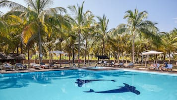 Una piscina al aire libre, camas de piscina gratis, sombrillas