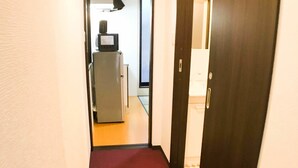 A narrow hallway with a red carpet leading to a door. - GH One More Heart Jujo 1 (Kyoto)
