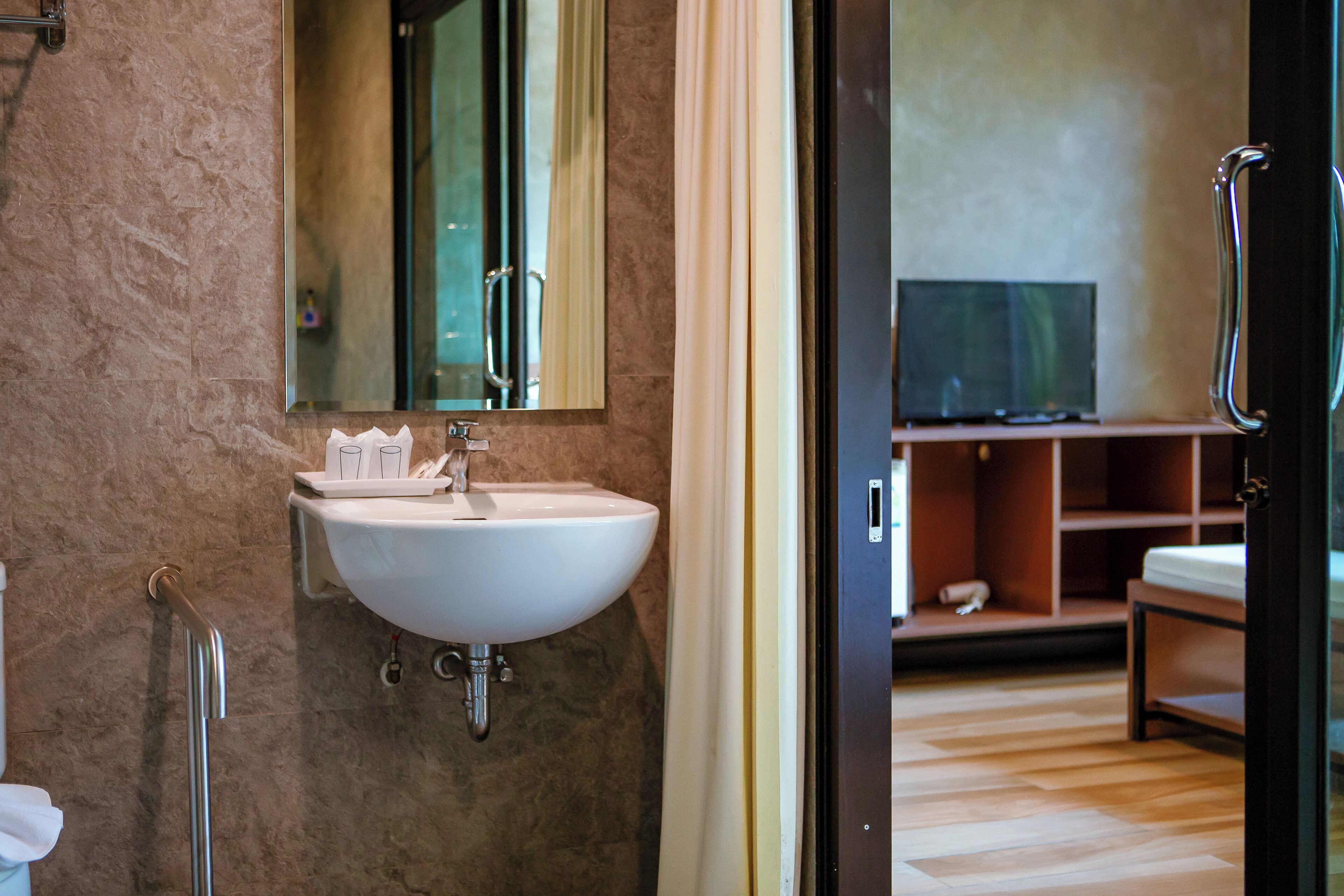 Un baño con lavamanos, espejo y ducha.