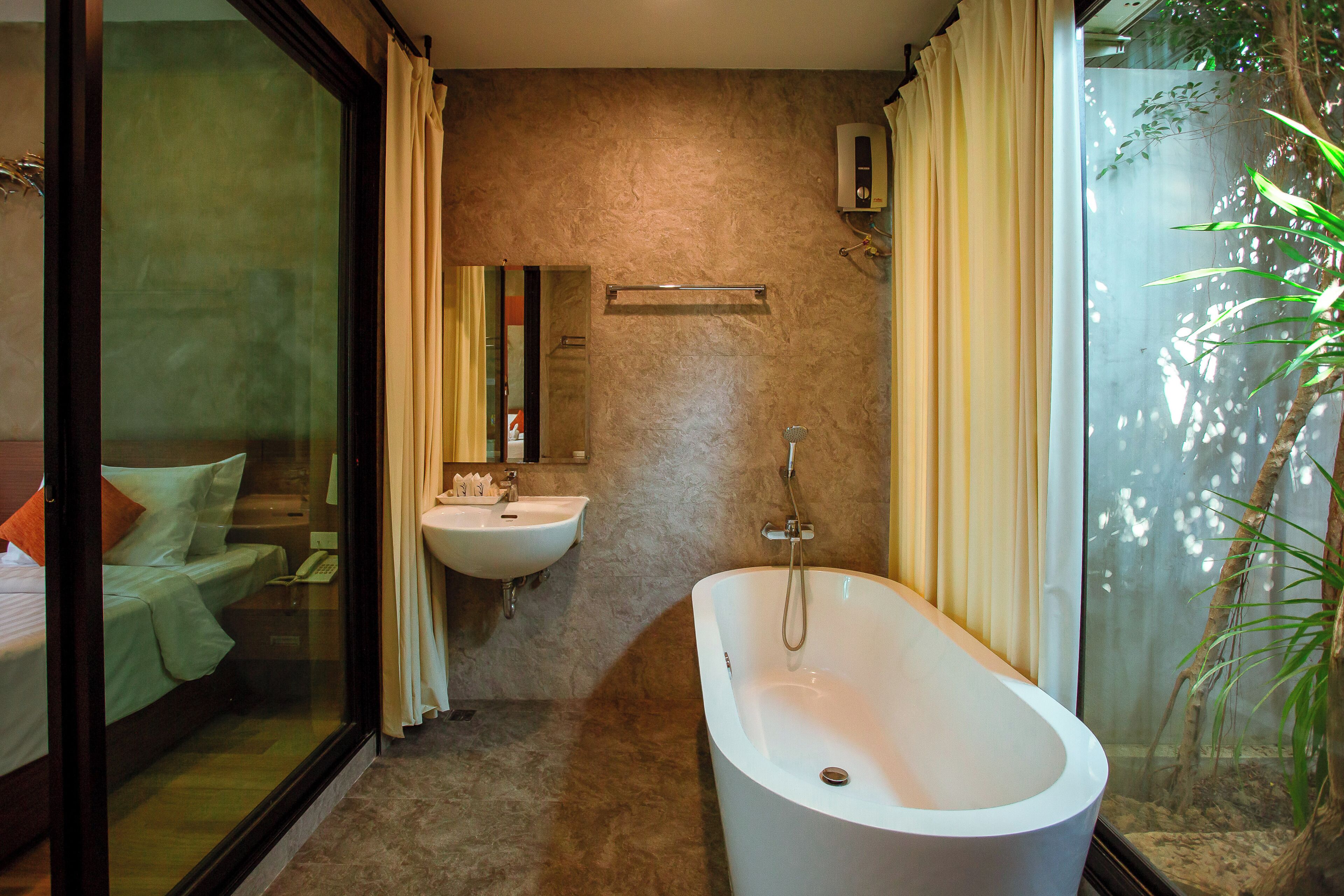 Un bagno con vasca, lavandino e cabina doccia in vetro.
