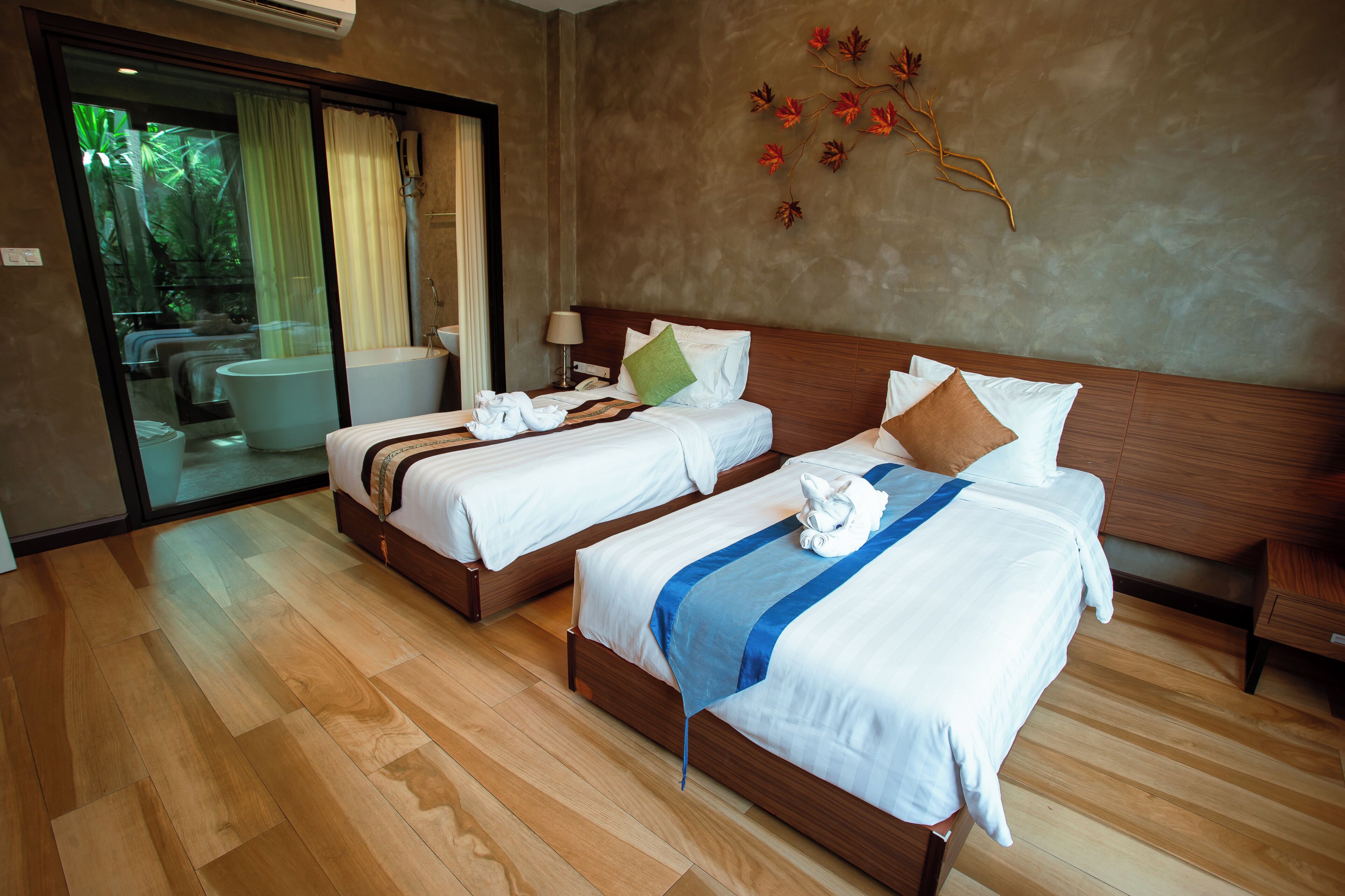 A hotel room with two beds, a bathtub, and a sliding glass door leading to a balcony.