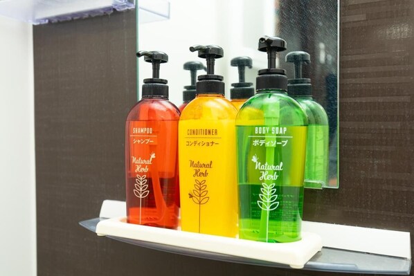 Una estantería con cuatro botellas de productos capilares naturales.