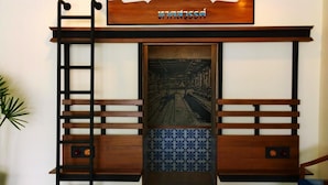 A wooden bench with a ladder, a decorative sign, and a patterned tile floor. - The Pho Thong Phuket (Phuket)