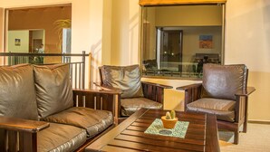 A modern living room with leather sofas and a wooden coffee table. - Sea View Backpackers - Hostel (Swakopmund)