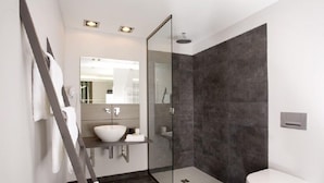 A modern bathroom with a glass shower enclosure, a white sink, and a toilet. - Pension Mariposa (Weimar)