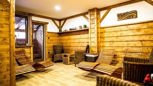 L’intérieur d’un chalet en bois, avec une cheminée, un coin salon et une fenêtre.