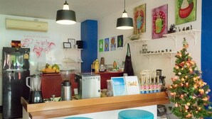 Una cocina con refrigerador, cafetera, licuadora y un árbol de Navidad.