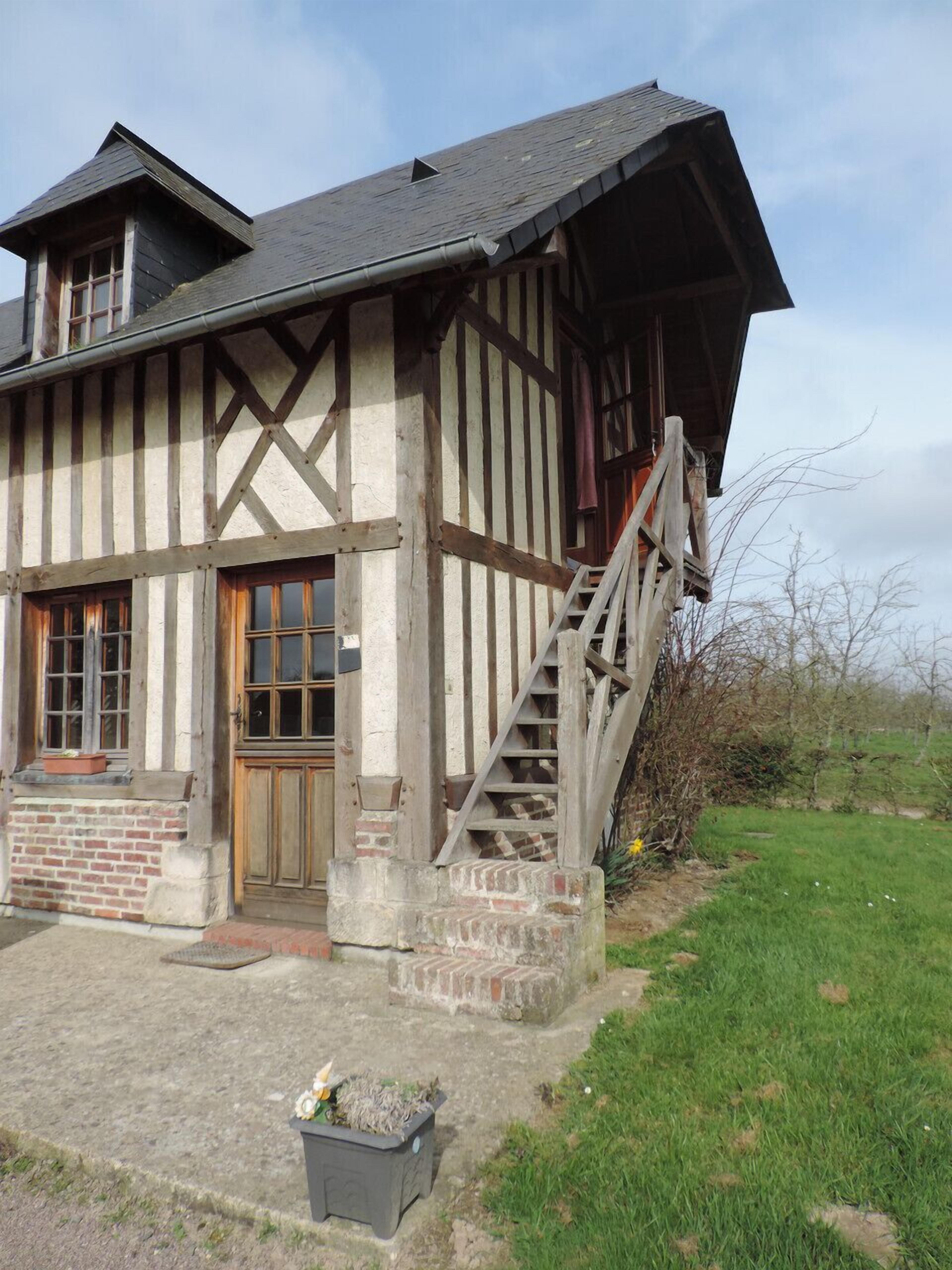 Una casa tradicional con entramado de madera y una escalera de madera que conduce a la entrada.