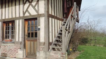 Una casa tradicional con entramado de madera y una escalera de madera que conduce a la entrada.