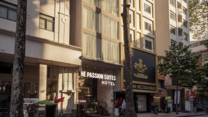 A multi-story hotel with a modern facade, large windows, and a visible massage service. - The Passion Suite Hotel (Ho Chi Minh City)