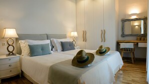Habitación de hotel con dos camas, una mesita de noche de madera, una silla y un espejo en la pared.