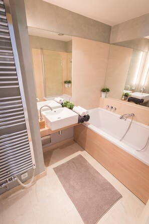 Uma casa de banho moderna com uma banheira grande, duas pias e um chuveiro.