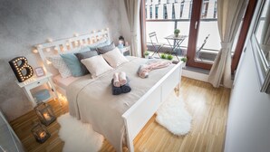 A neatly arranged bedroom with a bed, bedside table, and a view of the outside balcony. - Luxury apartment River Diamond residence (Prague)