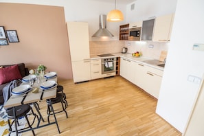 Enjoy cooking and dining in this well-equipped kitchen with modern appliances, a dining table, and ample storage.