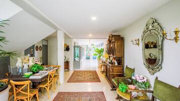 A spacious dining area with a long table, chairs, and a decorative mirror.