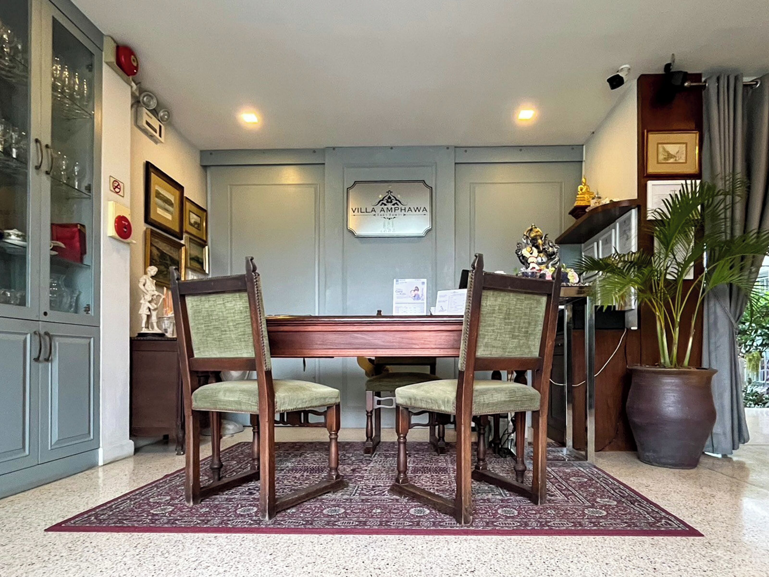 A room with a pool table, two chairs, a potted plant, and a sign reading "Villa Ampawa".