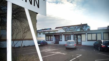 A parking lot with a sign for a motel named 'Looks Inn.'