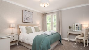 A bedroom with a bed, bedside tables, a desk, and a chair. - Durham Riverside Apartments (Durham)